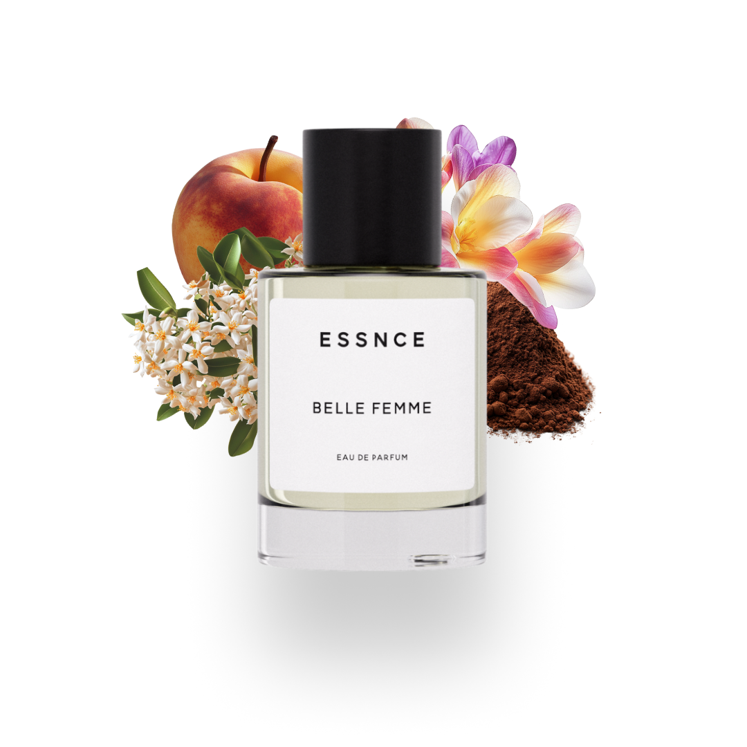 En flaska ESSNCE Belle Femme Eau de Parfum visas med en svart kork och en vit etikett. Bakom flaskan finns ingredienser som persika, fresia, osmanthus och kakao.