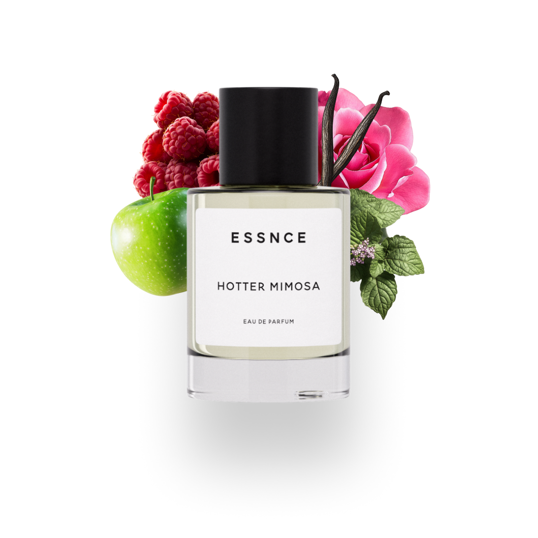 En flaska ESSNCE Hotter Mimosa Eau de Parfum visas med en svart kork och en vit etikett. Bakom flaskan finns ingredienser som hallon, äpple, rose absolute, vanilj och patchouli.