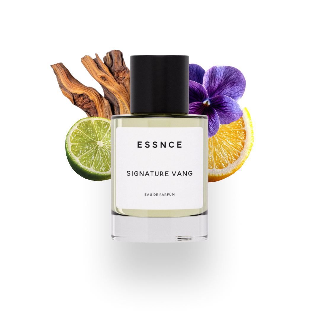 En flaska ESSNCE Signature Vang Eau de Parfum visas med en svart kork och en vit etikett. Bakom flaskan finns ingredienser som cederträ, bergamott, viol och citron.