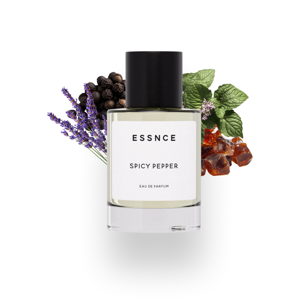 En flaska ESSNCE Spicy pepper Eau de Parfum visas med en svart kork och en vit etikett. Bakom flaskan finns ingredienser som peppar, lavendel, patchouli och amber.