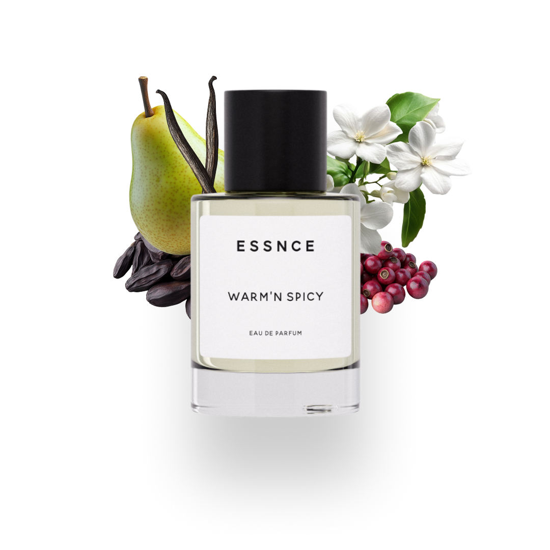 En flaska ESSNCE Warm’n spicy Eau de Parfum visas med en svart kork och en vit etikett. Bakom flaskan finns ingredienser som päron, jasmin, tonkabönor, vanilj och rosépeppar.